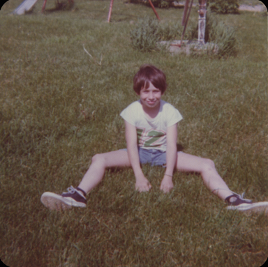 Boy in the grass backyard snapshot with deteriorated colour and amateur compostition.