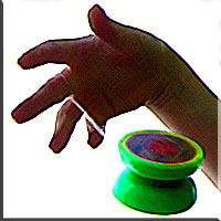 The green yoyo begins its descent from the hand above.